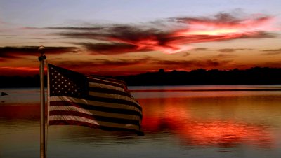 stock-footage-american-flag-flying-at-sunset-over-lake